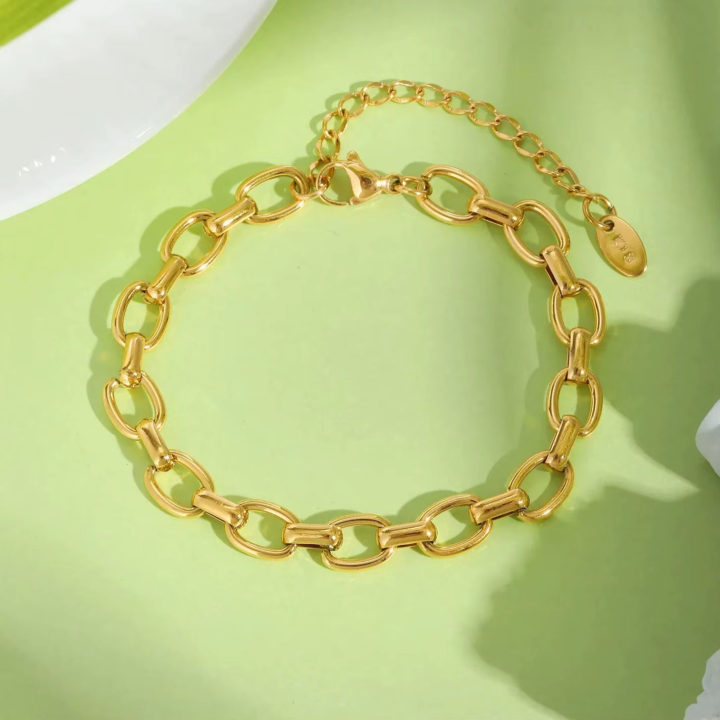 Bracelet Chaine Femme Doré en Acier Inoxydable sur fond vert