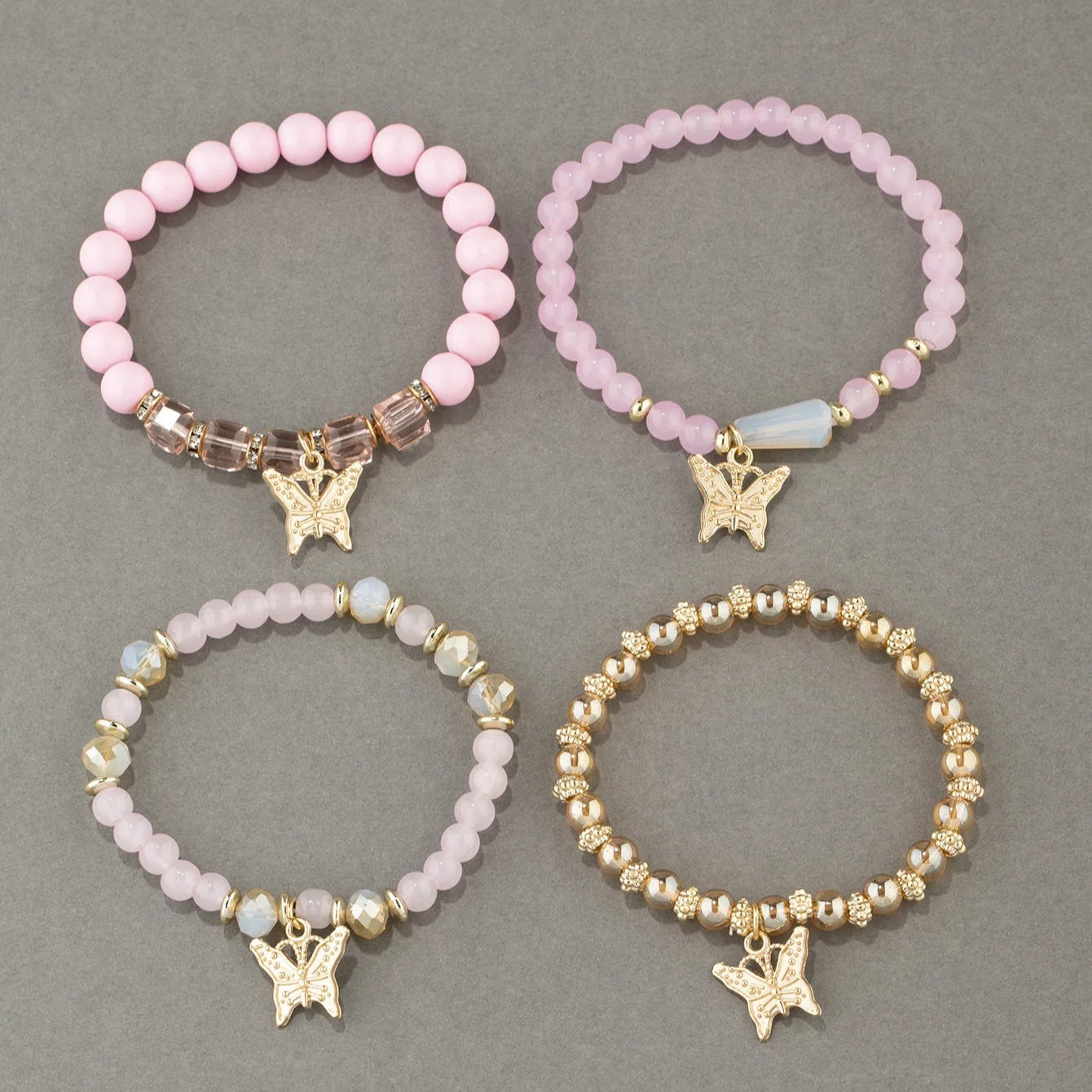Lot de 4 Bracelets Papillon Roses à Perles sur fond gris