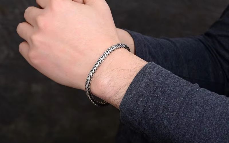 poignet homme qui porte un bracelet en argent style chaine.