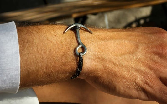 Homme portant un bracelet en corde relié par une ancre en métal.