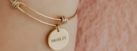 un bracelet doré gravé personnalisé en acier inoxydable autour d'un poignet